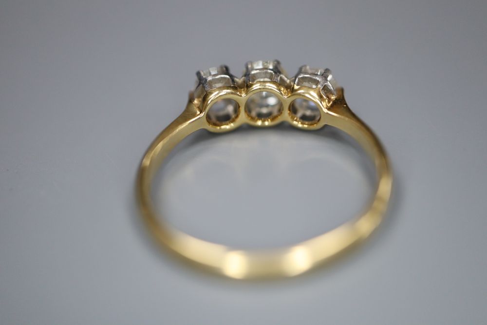 An 18ct and plat, three stone diamond ring, size O, gross 2.7 grams.